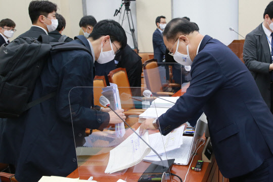 홍남기 부총리 겸 기획재정부 장관이 3일 국회에서 기획재정위원회 전체회의를 마치고 자료를 정리하고 있다. 연합뉴스